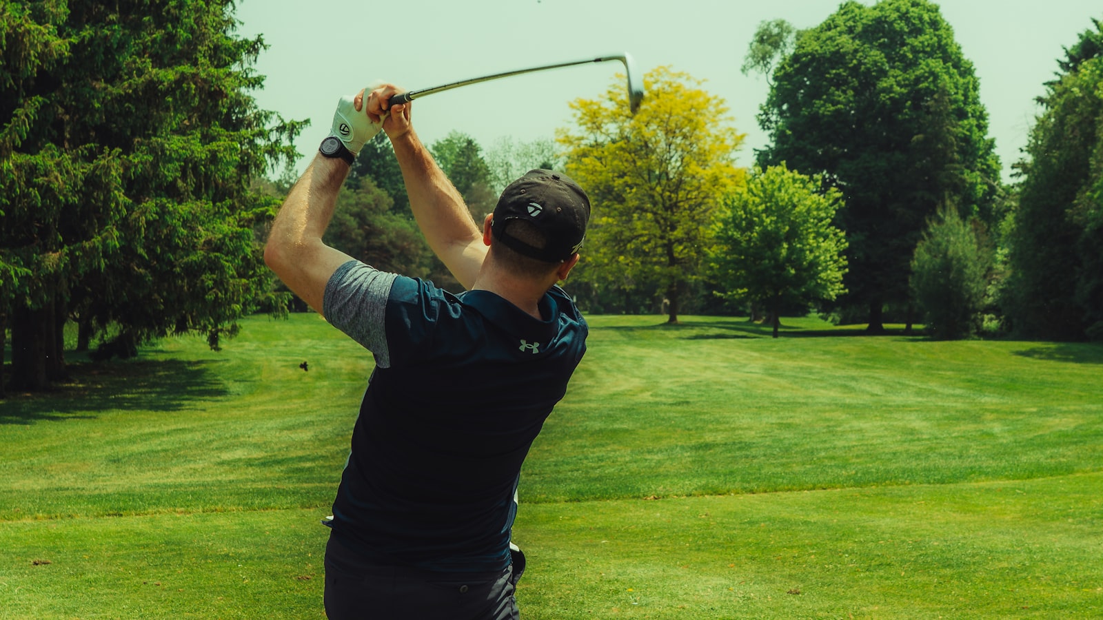 Golfeur en plein swing sur le parcours