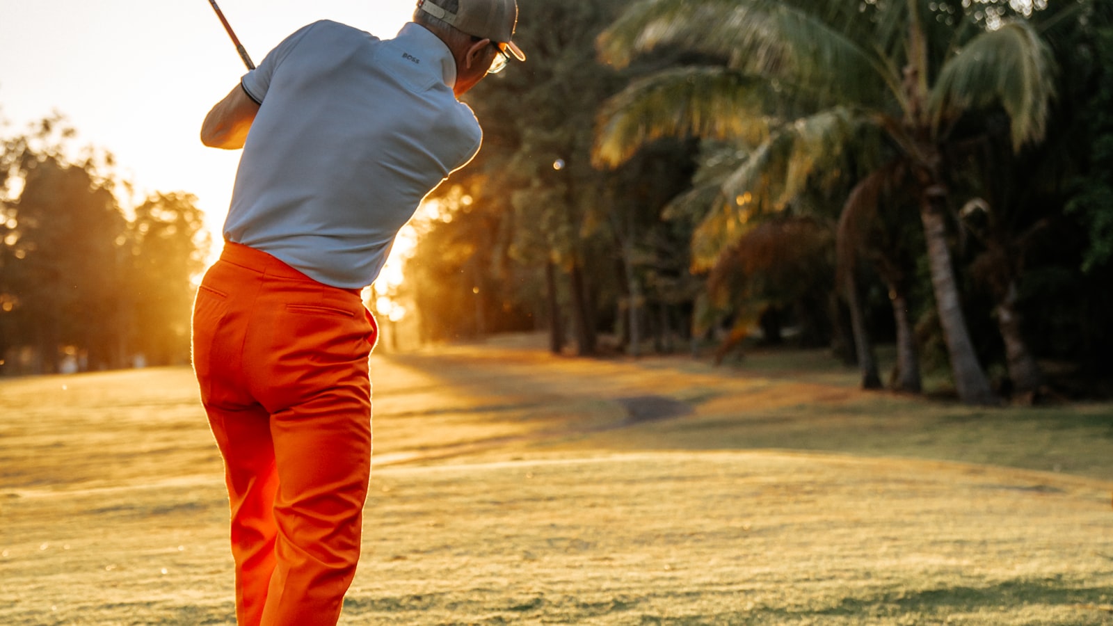 Golfeur en plein swing sur un fairway