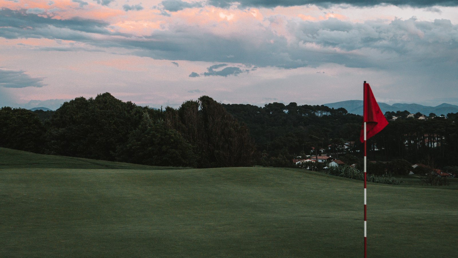 Green de golf avec drapeau rouge au petit matin